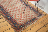Frayed fringe and indigo border with geometric patterns on a vintage distressed Malayer rug.