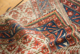 Distressed pile texture of Malayer rug with red flowers and saturated indigo border.