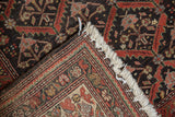 Distressed Kurdish rug corner showing cream fringe, muted pile, and hand-knotted foundation.