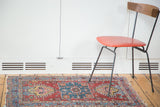 The charming and colorful character of a distressed Persian Heriz rug in a styled setting.