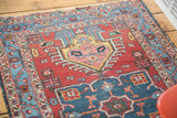 Colorful geometric patterns and worn, low-pile texture of a distressed vintage Persian Heriz rug.