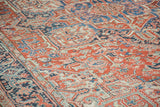 Intricate geometric flower and tendril motifs in brick red, indigo, and light blue.