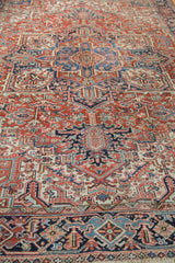 Vintage Heriz carpet: intricate geometric patterns in brick red, indigo, and ivory.