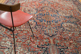 Vintage Heriz carpet featuring brick red, indigo, and softened green geometric floral patterns.