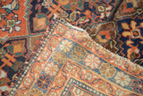 Distressed vintage Persian Afshar rug's tattered edge, revealing terra cotta, blue, and saffron tribal patterns.