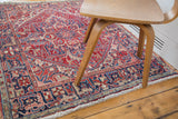 Secured edge of a vintage Northwest Persian rug, gerus style arabesque in cherry red and navy.