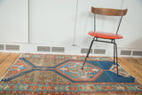 Distressed antique Northwest Persian rug with indigo, rust, coppery green geometric patterns.