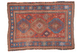 Distressed Antique Kazak rug featuring madder red field, triple tribal medallions, and sky blue borders, 4' x 5'6