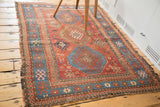 Distressed antique Kazak rug, showing madder red field, sky blue and pawn design borders.