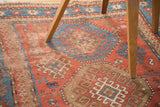 Distressed antique Kazak rug with madder red field and sky blue hooked guls.