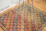 Antique Shirvan rug showcasing distressed hexagonal medallions with madder red, saffron, and blue.