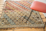 Corner of distressed antique Shirvan rug featuring a hexagonal field and geometric border.