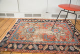 Distressed Antique Karaja rug corner, revealing time-softened bronze, light blue, and blush geometric patterns.