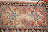 Vibrant geometric patterns in coral, light blue, and faded green with textural distress.
