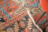 Folded corner of antique Karaja rug, showing hand-knotted foundation, fringed edge, distressed geometric pattern.