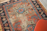 Distressed bronze and blush field with light blue geometric patterns on an antique Karaja rug.