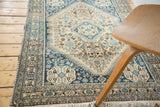 Abadeh rug corner with intricate teal blue, ivory, brown Qashqai border and knotted fringe.