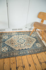 Vintage Abadeh rug corner: Qashqai motif, teal blue, peach field, and edge curl.
