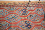 Close-up of antique Northwest Persian rug's running red channels and indigo blue water pools.