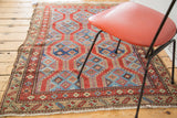 Northwest Persian rug corner, bold red and indigo geometric patterns, detailed border, aged selvage.
