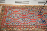 Geometric border and blue patterned running channels on the antique Northwest Persian rug.