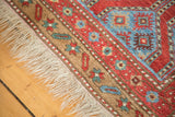 Antique Northwest Persian rug's natural fringe, with camel border and red, indigo motifs.