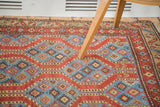 Close-up of vintage Northwest Persian rug's geometric running channels in red and indigo pools.