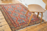 Geometric madder red field and indigo blue channels on a vintage Northwest Persian rug.