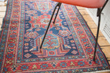 Artfully distressed Heriz rug's deep indigo and cherry red star and leaf borders.