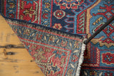 Vintage distressed Heriz rug corner, displaying secure fringe and the tight weave of its foundation.