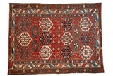 Distressed Baktiari rug, allover hexagonal floral medallions in aubergine, blue, and green.
