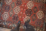 Distressed Persian Baktiari rug detail, hexagonal panels with blossoming aubergine, denim blue florals.
