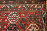 Distressed Baktiari rug with geometric aubergine red and denim blue floral panels.