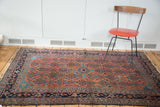 Distressed Malayer rug shows splayed sky blue medallion and repeating herati motif.