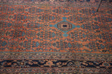 Vintage distressed Malayer rug detail: sky blue Herati pattern on rich brick red field.