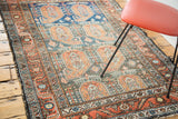 Softened madder root border, charcoal slate blue field, and paisley boteh of a Malayer rug.