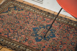Distressed Malayer rug with faded dusty rose field, blue herati motifs, and tulip border.