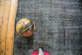 Distressed black and gray overdyed texture of a vintage gallery runner.