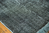 Distressed acid wash texture of the dark vintage overdyed runner with blue fringe.