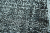 Distressed vintage overdyed rug pile texture in abstract black and light gray.