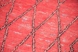 Distressed rag rug texture, faded cinnabar red, and black lattice pattern on a Moroccan runner.