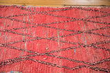 Faded cinnabar red distressed Moroccan runner, visible rag rug construction, diagonal lattice.