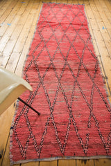 Textured distressed pile showing faded cinnabar red and dark diamond lattice.