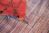 Distressed cinnabar red cut pile fused with multicolor striped rag rug weave.