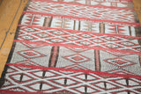 Embroidered jijim panels on a vintage Moroccan runner with geometric motifs in red and ivory.