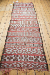 Embroidered Moroccan jijim with horizontal geometric panels in faded cinnabar, ivory, and charcoal.