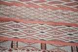 Embroidered horizontal geometric bands on a vintage Moroccan jijim runner in cinnabar and ivory.