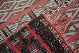 Embroidered Moroccan jijim rug showing textured horizontal panels and red fringe.