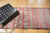 Stylized geometric patterns across horizontal panels of this Moroccan runner, in cinnabar, ivory, beige.