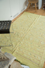 Embroidered geometric floral guls and serpent motifs on a lime green Moroccan kilim.